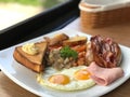 close up breakfast plate include fried eggs, ham, sausages, potatoes, tomatoes, mushrooms, beans Royalty Free Stock Photo