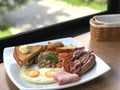close up breakfast plate include fried eggs, ham, sausages, potatoes, tomatoes, mushrooms, beans Royalty Free Stock Photo