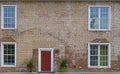 Close up of a brick building with a red door