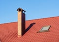 Close up of brick chimney and skylight on the metal tile roof Royalty Free Stock Photo