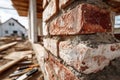 Close-up of a brick wall being constructed on a building site, showcasing the process of bricklaying with tools and a house under Royalty Free Stock Photo