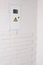 Box for electrical machines and a meter. The brickwork on the wall is white. Electricity Royalty Free Stock Photo