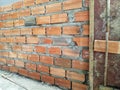 Close-Up of Brick Wall Under Construction Showcasing Mortar and Laid Bricks with Wooden Framework for Support Royalty Free Stock Photo