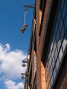 Close-up of brick wall warehouse building exterior with pulleys against blue sky with white clouds. Royalty Free Stock Photo