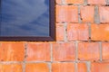 Close-Up of Brick Wall with Window Reflecting Sky Royalty Free Stock Photo