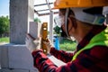 Close-up bricklayer builder using the water level, check the inclination of autoclaved aerated concrete blocks. Walling,