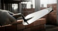 Close-Up of Bricklayer\'s Hand Holding Trowel Over Freshly Laid Red Bricks in Construction Site with Dramatic Lighting Royalty Free Stock Photo