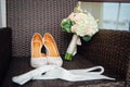 Close-up of bridal bouquet of roses, wedding flowers for the ceremony on the bed in a hotel room with white shoes Royalty Free Stock Photo