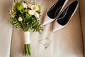 Close-up of bridal bouquet of roses, wedding flowers for the ceremony on the bed in a hotel room with white shoes Royalty Free Stock Photo