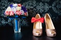 Close-up of bridal bouquet of roses, wedding flowers for the ceremony on the black table in a hotel room with white shoes Royalty Free Stock Photo