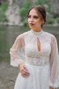 close up. The bride in a white dress on the bank of a mountain river. Royalty Free Stock Photo