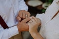 Close-up of bride and groom holding hands with wedding rings at reception outside in the backyard. Royalty Free Stock Photo