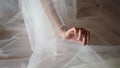 Close-up, the bride holds a fatu with one hand