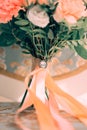 Close-up of the bride`s wedding bouquet, coral flowers, ribbons. Selective focus