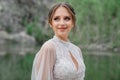 close up. The bride in a white dress on the bank of a mountain river. Royalty Free Stock Photo