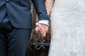 Close up of bride in white dress and groom in suit just married holding hands together following wedding ceremony stood in doorway Royalty Free Stock Photo