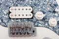 Close up of bridge and humbucker and controls on white white electric guitar, studio shoot