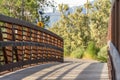 Close up of a bridge with metal guardrail and wood deck on a sunny day