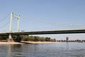 A close up of a bridge with a natural riverbank andskyscraper in the background at the rhine river in cologne germany