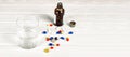 Close-up of bright colored medical tablets, a bottle of medicine and capsules with medicines and a glass of water