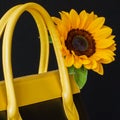 Close-up bright handbag from genuine leather, decorated flower, sunflower. Concept of shopping, manufacturing, lifestyle