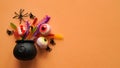 Close-up of bright jelly candies,spiders,eyes,jaws,worms and bats in a Halloween pot on an orange background,top view, flat lay,