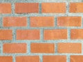 Close-up of a bright orange brick wall, featuring a textured surface with various shades of orange Royalty Free Stock Photo