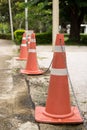 Close up bright orange traffic cones standing in a row on asphalt Royalty Free Stock Photo