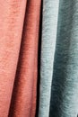 Close-up bright pink and blue curtains in thin and thick vertical folds of dense fabric. Textured abstract backgrounds and