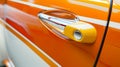 Close-up of a bright and sleek car handle. The modern design and vivid color of the car door are striking. The Royalty Free Stock Photo