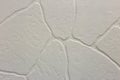 Close-up of bright white plastered uneven stucco wall. Abstract texture, chaotic copy space background. Decorative grunge space Royalty Free Stock Photo