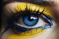 A close-up of the bright yellow and blue paint on the woman\'s eye, symbolising the hardships the Ukrainians have endured. A