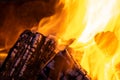 Close up of brightly burning wooden logs with yellow hot flames of fire at night Royalty Free Stock Photo