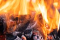 Close up of brightly burning wooden logs with yellow hot flames of fire at night Royalty Free Stock Photo