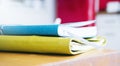 Close-up of brightly colored notebooks on wooden table on red background side view of the object, free space, blurred for your tex Royalty Free Stock Photo