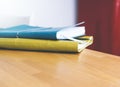 Close-up of brightly colored notebooks on wooden table on red background side view of the object, free space, blurred and free Royalty Free Stock Photo