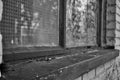 Close up of a broken boarded up window and sill with peeling paint and graffiti Royalty Free Stock Photo