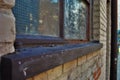 Close up of a broken boarded up window and sill with peeling paint and graffiti Royalty Free Stock Photo