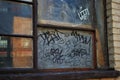 Close up of a broken boarded up window and sill with peeling paint and graffiti Royalty Free Stock Photo