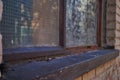 Close up of a broken boarded up window and sill with peeling paint and graffiti Royalty Free Stock Photo