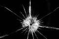 Close up of broken, cracked pane of glass with central bullet hole, on black background Royalty Free Stock Photo