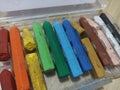 A close up of broken crayons of various colours