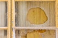 Close-Up of a Broken Glass Window with Yellow Frames and Cracks Royalty Free Stock Photo