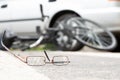 Close-up of broken glasses on a road with a blurred bike and car Royalty Free Stock Photo