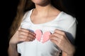 Woman standing in sunlight wearing white shirt and holding broken heart on chest Royalty Free Stock Photo