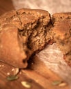 Close-up broken homemade fresh bread and pumpkin seeds on parchment paper the wooden table