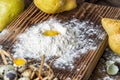 Close up. Broken quail egg in a hill of white flour on the wooden board. Rustic still life Royalty Free Stock Photo