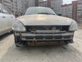 Close up of broken rusty car on city street. Damaged bumper of car after accident. Concept of careless driving.