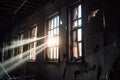 close-up of broken windows in abandoned building, with eerie light shining through