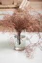 Close up of bronze colored ferns in glass vase